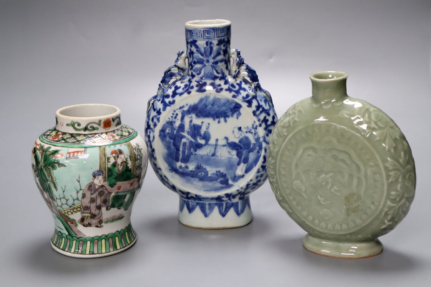 A Chinese blue and white moon flask, a Chinese celadon glazed moon flask and a famille verte baluster vase, tallest 21cm